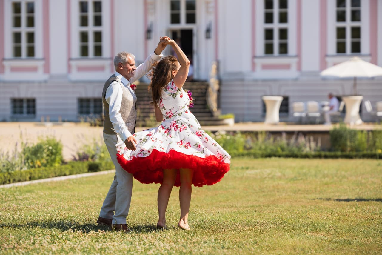 Braut dreht sich im Petticoat-Kleid, im Hintergrund das Schloss