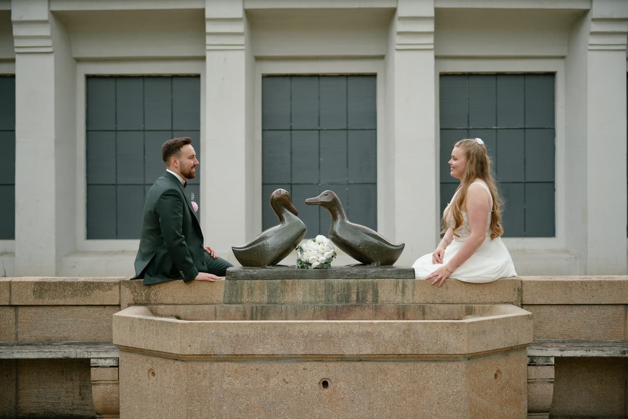 Brautpaar sitzt an einem Brunnen mit zwei Bronzeenten in Berlin-Schöneberg