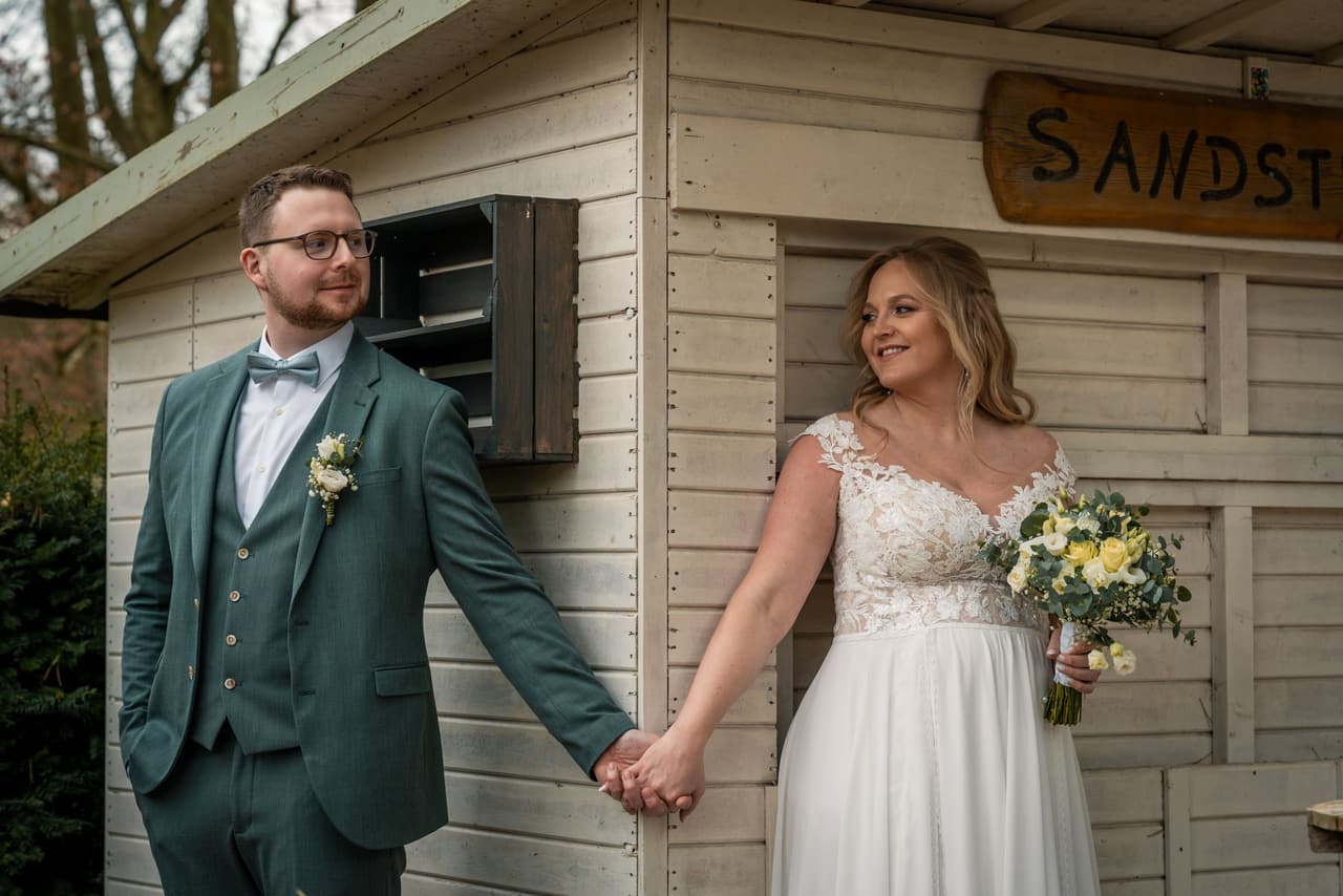 Hochzeit in Dortmund, Brautpaar hält Händchen nach der Trauung im Park