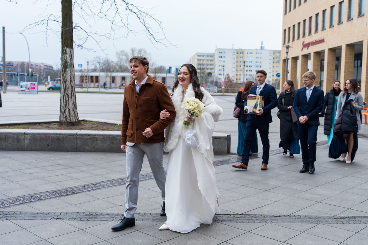 Hochzeit im Standesamt Marzahn Hellersdorf, Brautpaar verlässt das Standesamt mit Gästen
