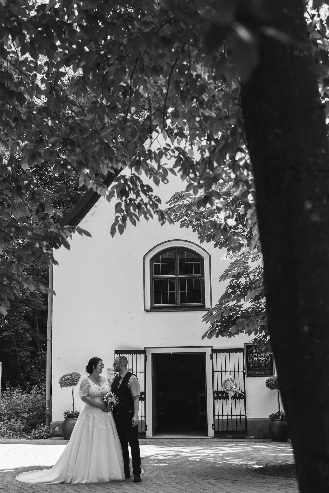 Kirchliche Trauung in Brandenburg, Brautpaar vor der Kirche mit historischer Architektur